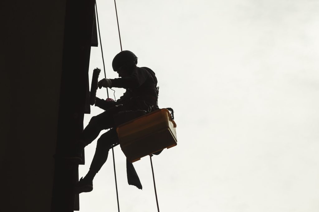 Trabajador realizando trabajos verticales en altura con equipo de seguridad.